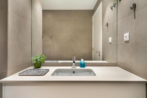 bagno con lavandino e specchio di WHome Prime Location w AC 3-Bed Duplex Perfect for Families ONLY a Lisbona