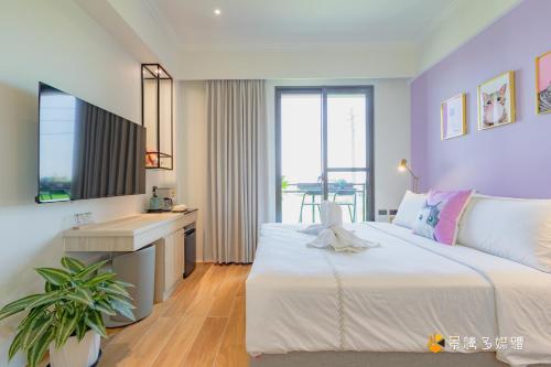 una camera da letto con un grande letto bianco e una scrivania di Mika BnB a Shih-t'ou-wei