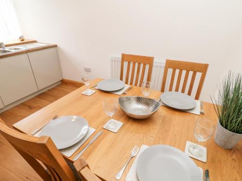 a dining room table with white plates and wine glasses at Flat Above 27 in Bishop Auckland