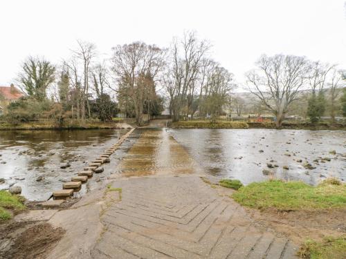 a bridge over a river with ducks in the water at Flat Above 27 in Bishop Auckland