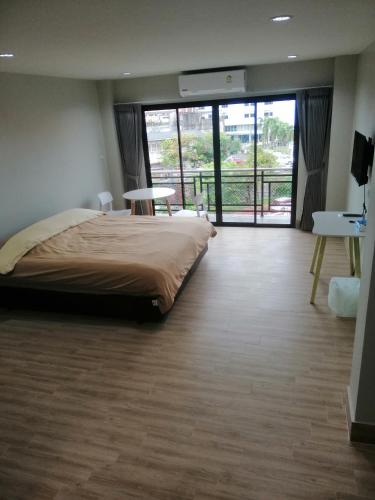 a bedroom with a large bed and a large window at IHome Hostel Hatyai in Songkhla