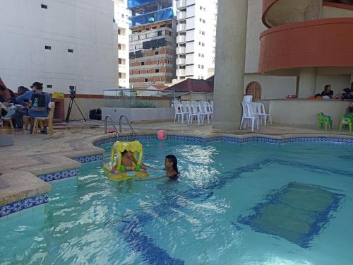 una chica jugando en una piscina con un juguete en Apartaestudio Altamar en Cartagena de Indias