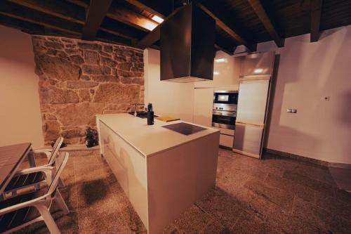 a kitchen with a counter and a refrigerator in a room at Casa Rural Vilar de Flores in Ourense