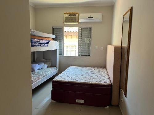 una piccola camera con due letti e una finestra di Mar azul Enseada a Guarujá
