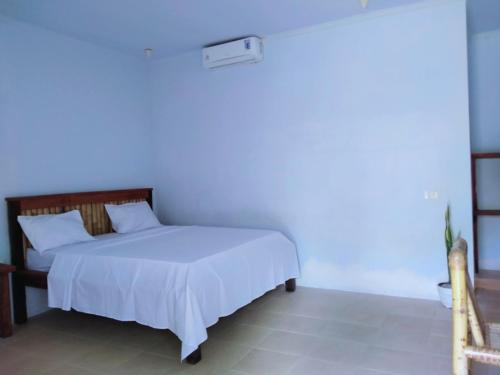 a bedroom with a bed with a blue light on it at Mengalung Bungalow in Kuta Lombok