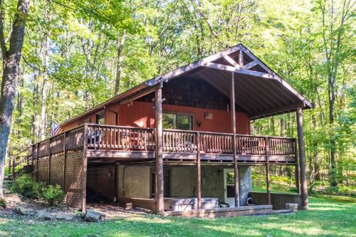 a cabin in the woods with a wrap around deck at Woodside Retreat in McHenry
