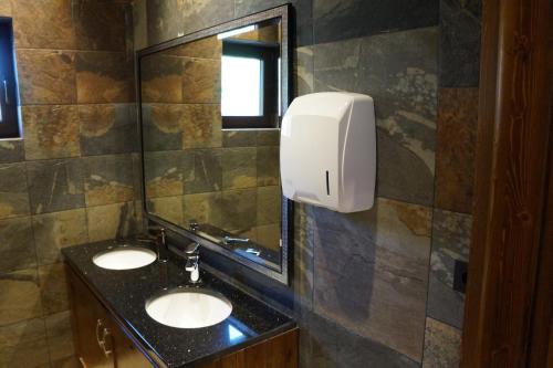 a bathroom with two sinks and a mirror at Four Winds in Krynica Morska