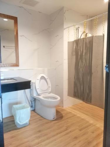 uma casa de banho com um WC, um lavatório e um espelho. em IHome Hatyai em Hat Yai