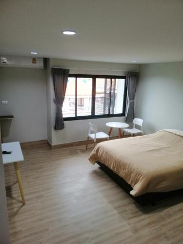 a bedroom with a bed and a desk and a window at IHome Hatyai in Hat Yai