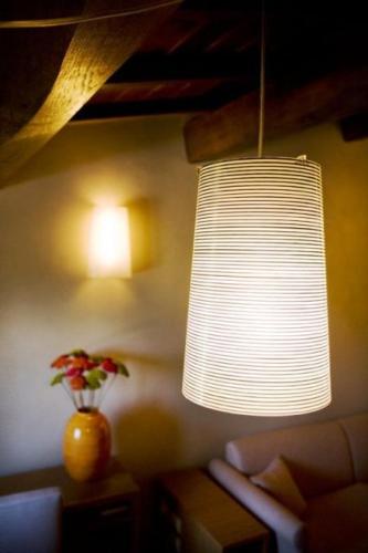a living room with a lamp and a vase of flowers at Country House Casco Dell'Acqua in Trevi
