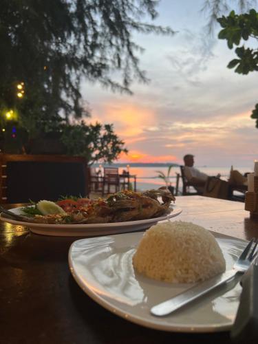 a plate of food on a table with a plate of rice at Ao Thong beach Resort in Khao Lak