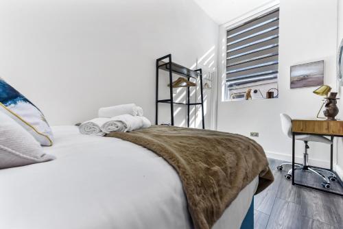 a white bedroom with a bed and a window at Comfy and Contemporary One Bedroom Flat in London