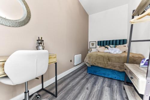 a bedroom with a bed and a desk and a chair at Comfy and Contemporary One Bedroom Flat in London