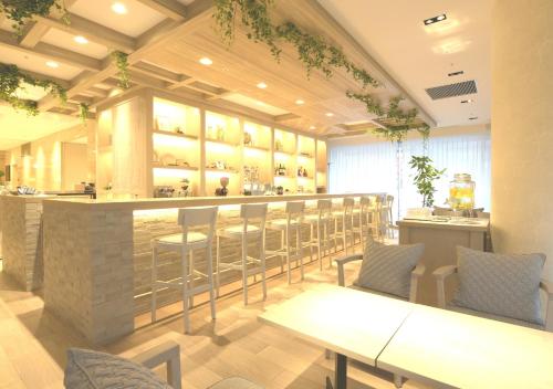 a restaurant with a bar with tables and chairs at Oriental Hotel Fukuoka Hakata Station in Fukuoka