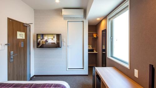 een kamer met een bed en een raam bij Hotel Reference Reisen in Fukuoka