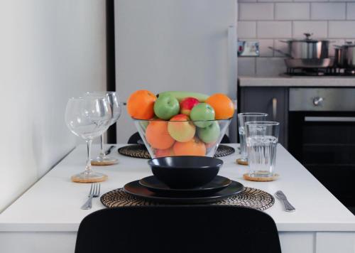 a bowl of fruit on a kitchen counter with glasses at Victoria Cottage in Cannock