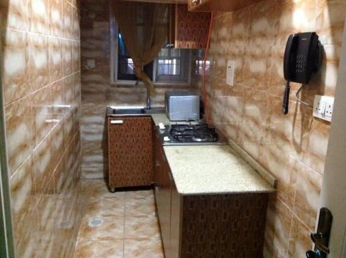 a small kitchen with a stove and a phone at Blue-View Suites & Apartments in Abuja