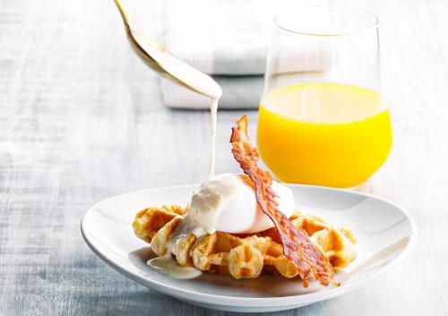 a plate of waffles with ice cream and a glass of orange juice at Oriental Hotel Fukuoka Hakata Station in Fukuoka