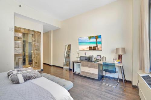 a bedroom with a bed and a desk with a laptop at Good Hotels Downtown Denver in Denver
