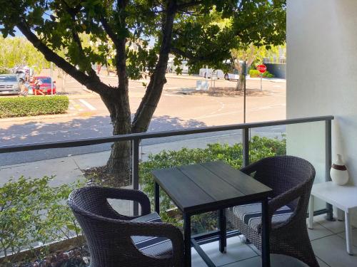 a table and chairs on a balcony with a tree at Blue on Blue Deluxe King or Twin room, steps from ferry, amazing pool, wifi in Nelly Bay