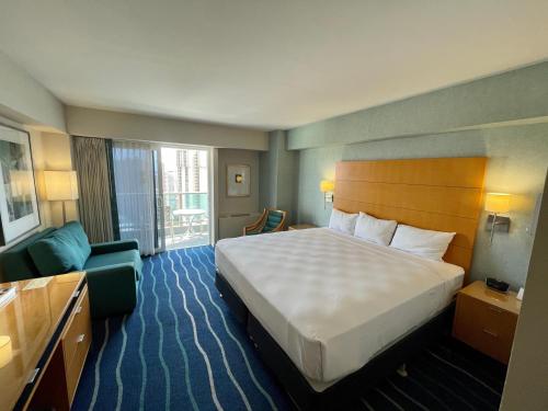 ホノルルにあるAla Moana Hotel 31st floorの大きなベッドと窓が備わるホテルルームです。