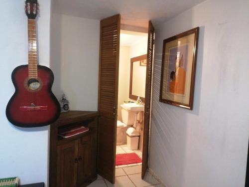a guitar hanging on a wall next to a bathroom at ¡Confortable y Privado! - Ubicado en Av. principal in Guadalajara