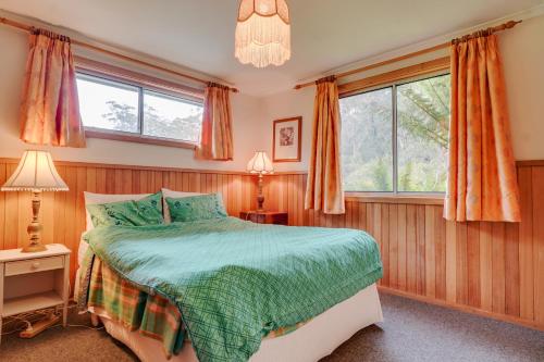 a bedroom with a bed and two windows at Eureka Farm in Scamander