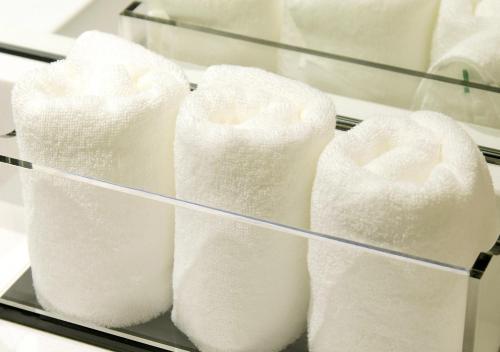 a stack of white towels on a shelf at Oriental Hotel Fukuoka Hakata Station in Fukuoka