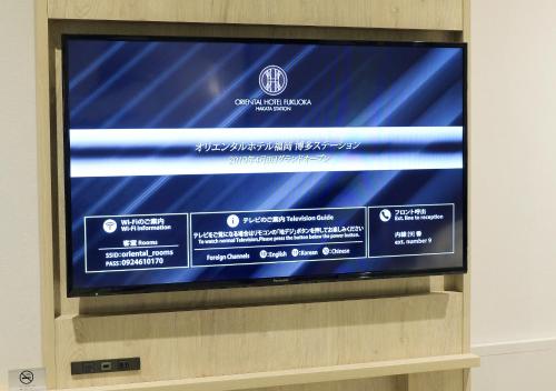 a large flat screen tv sitting on top of a wall at Oriental Hotel Fukuoka Hakata Station in Fukuoka