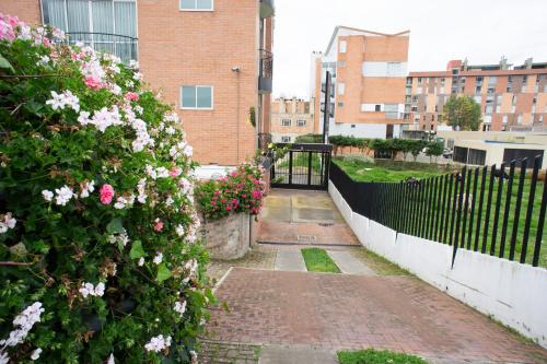 a garden with pink flowers and a fence at Hotel San Marcos in Paipa