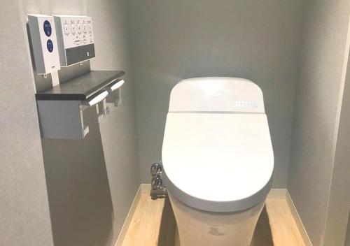 a white toilet in a bathroom with a microwave at Oriental Hotel Fukuoka Hakata Station in Fukuoka