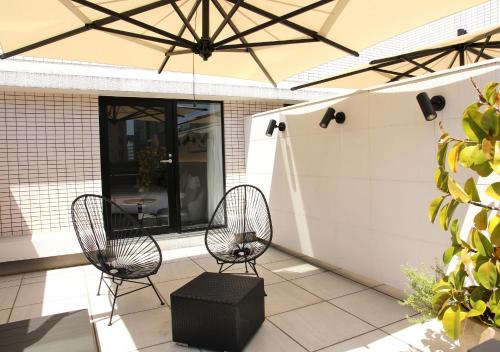 two chairs and a table on a patio at Oriental Hotel Fukuoka Hakata Station in Fukuoka