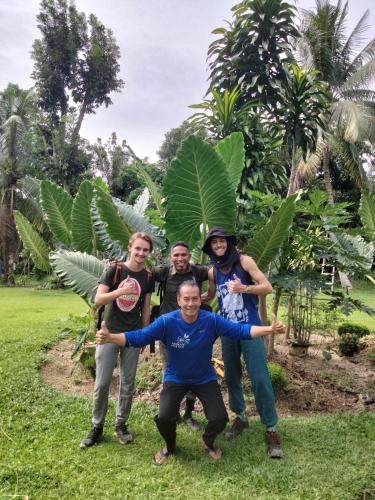 a group of people posing for a picture in the grass at Wisma Batu Mandi in Bukit Lawang