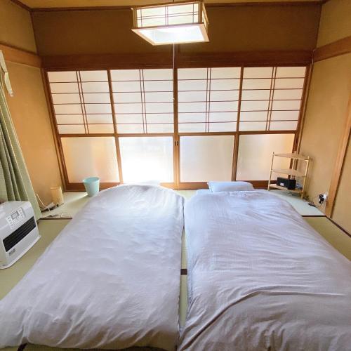 a large white bed in a room with a window at mooi 宮町 in Aizuwakamatsu