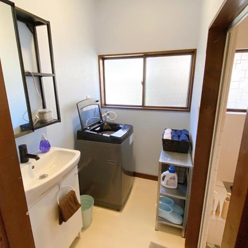 a bathroom with a sink and a washing machine at mooi 宮町 in Aizuwakamatsu