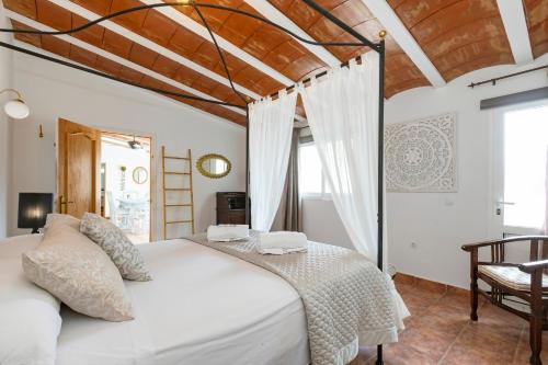 サン・ラファエル・デ・サ・クレウにあるVilla in Ibiza Town with private pool, sleeps 10の木製の天井のベッドルーム1室(白いベッド1台付)