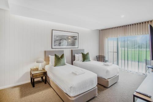 a hotel room with two beds and a window at 13th Beach Golf Lodges in Barwon Heads