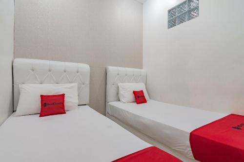 RedDoorz near Prujakan Station Cirebon tesisinde bir odada yatak veya yataklar