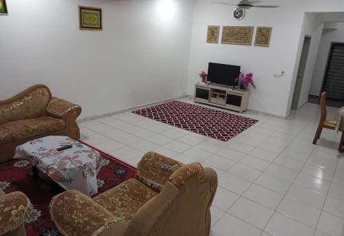 uma sala de estar com um sofá e uma televisão em Homestay UmahMak em Bandar Puncak Alam