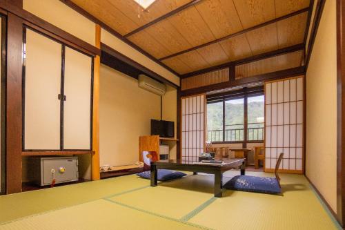 a living room with a table in the middle of a room at Oyado Eitaro in Takayama