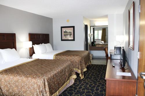 a hotel room with two beds and a television at Greenlight Inn & Suites St James in Saint James