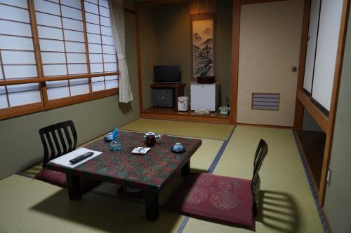 un tavolo e due sedie in una stanza con tavolo di Oyado Eitaro a Takayama