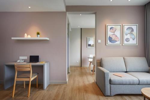 a living room with a couch and a desk at Hotel Komune Living & Wellness Kuala Lumpur in Kuala Lumpur