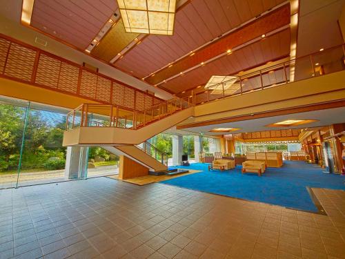 eine große Lobby mit einer Treppe in einem Gebäude in der Unterkunft Yukai Resort Premium Seiunkaku in Awara
