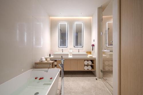 a white bathroom with a tub and a sink at HOTEL ANDI Townscape Wuhan in Wuhan