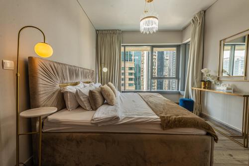 1 dormitorio con 1 cama grande y ventana grande en FIRST CLASS 2BR with full BURJ KHALIFA and FOUNTAIN VIEW, en Dubái