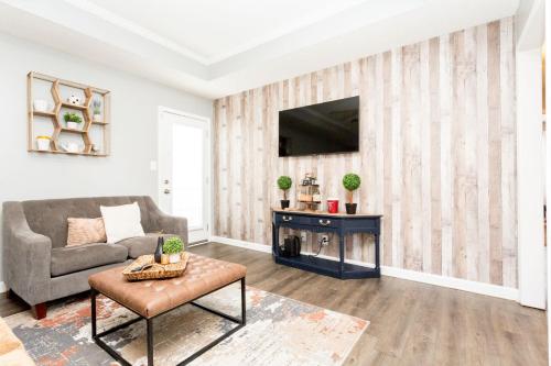 a living room with a couch and a tv at Once-In-A-Lifetime Coffee-Themed Stay For Up To 8 in Clarksville