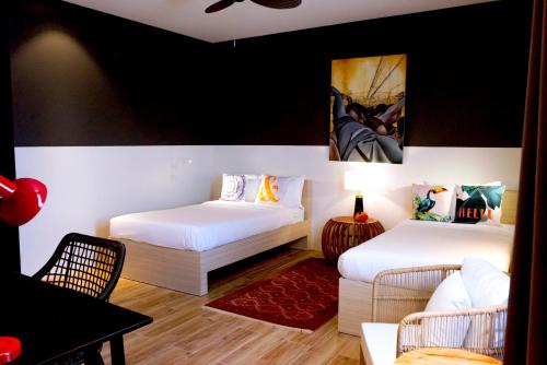 a room with two beds and a table and chairs at UNWND Boutique Hotel Dumaguete in Dumaguete