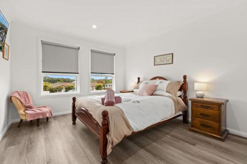 ein Schlafzimmer mit einem Bett und zwei Fenstern in der Unterkunft Libbity's at The Point by Experience Jervis Bay in Sanctuary Point