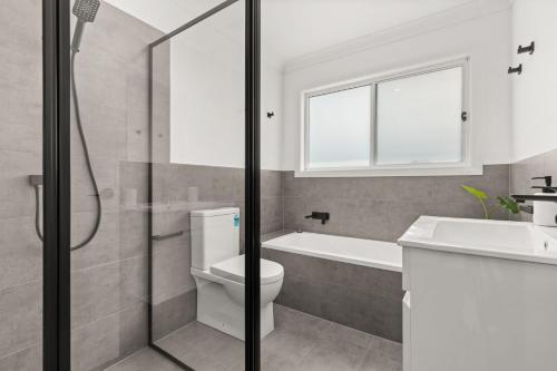 a bathroom with a toilet and a sink and a shower at Libbity's at The Point by Experience Jervis Bay in Sanctuary Point